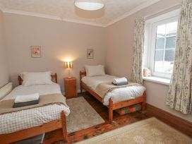 A bedroom with two beds and a window at 1 Alpha Cottages in Tenby