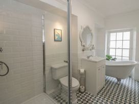 A bathroom with a shower, toilet, sink, and bathtub at 1 Alpha Cottages in Tenby