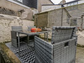 An outdoor seating area with a table and chairs at 1 Alpha Cottages in Tenby