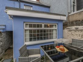 An outdoor seating area with a table and chairs at 1 Alpha Cottages Tenby