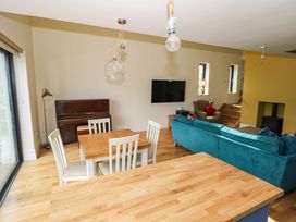 A living room with a piano and dining area at The Cottage in Leenane, County Galway