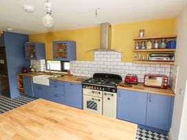A kitchen with a stove, sink, and cupboards at The Cottage in Leenane, County Galway