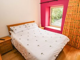 A bedroom with a bed and window at The Cottage in Leenane, County Galway