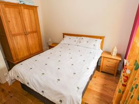 A bedroom with a bed and wardrobe at The Cottage in Leenane, County Galway