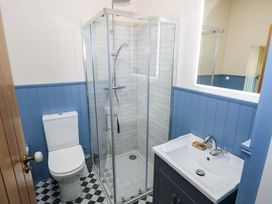 A bathroom with a shower, toilet, and wash basin at The Cottage in Leenane, County Galway