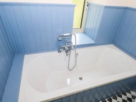 A bathtub with a faucet and a window at The Cottage in Leenane, County Galway