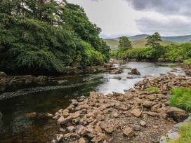 A river surrounded by rocks and trees at The Cottage in Leenane, County Galway