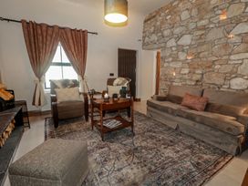 A living room with a stone wall and furniture at Hanowen House, Dungloe, County Donegal