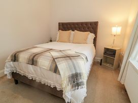 A bedroom with a bed, nightstand, and lamp at Hanowen House, Dungloe, County Donegal
