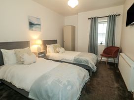 A bedroom with two beds and a wardrobe at Hanowen House, Dungloe, County Donegal