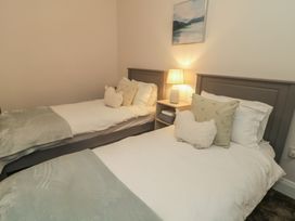 A bedroom with two single beds and a lamp on a nightstand at Hanowen House, Dungloe, County Donegal