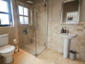 A bathroom featuring a shower, toilet, and sink at Hanowen House, Dungloe, County Donegal