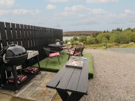 An outdoor dining area with grill and chairs at Hanowen House Dungloe, County Donegal