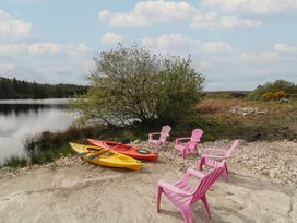A lakeside area with kayaks and pink chairs at Hanowen House, Dungloe, County Donegal