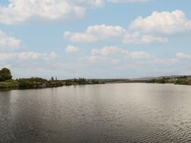 A river with trees and houses beside it at Hanowen House in Dungloe, County Donegal