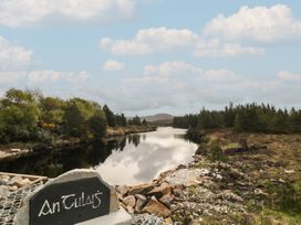 A river with surrounding trees and a sign in An Tulaigh at Hanowen House Dungloe, County Donegal