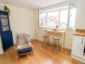 A kitchen with stools and a table near an open window at Flat 3 