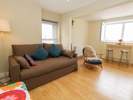 A living room with a sofa and a table at Flat 3