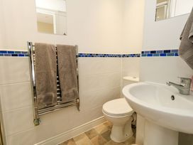 A bathroom with a toilet, sink, and towel rail at Flat 3