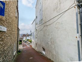 An alley with buildings on both sides and a street sign at Flat 3