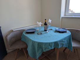 A dining room with a table set for two with wine and cutlery at Flat 3 Fortuneswell
