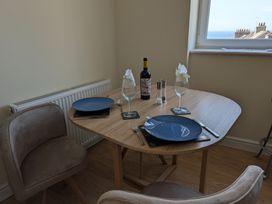A dining table set with wine glasses and a bottle of wine at Flat 3 in Fortuneswell