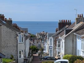 A view of houses lining a road with the sea in the background at Flat 3, Fortuneswell