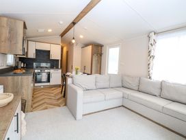 A living room with a sofa and kitchen area at Caravan in Great Yarmouth