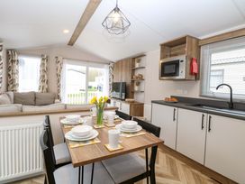 A living room with a dining area and kitchen appliances at Caravan in Great Yarmouth
