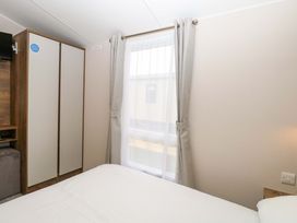 A bedroom with a bed and wardrobe at Caravan in Great Yarmouth