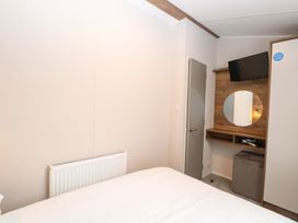 A bedroom with a bed and television at Caravan in Great Yarmouth