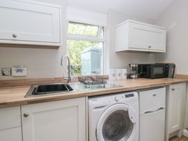 A kitchen with a sink and washing machine at Fellfoot Cottage