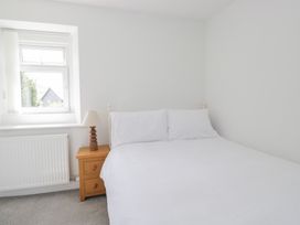 A bedroom with a bed and lamp at Fellfoot Cottage