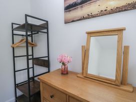A bedroom with a shelf and mirror at Fellfoot Cottage