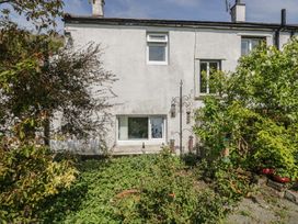 A house with a garden and bird feeders at Fellfoot Cottage