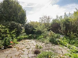 A garden area with stone paving and various plants at Fellfoot Cottage