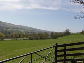 A view of fields and mountains with a gate at Fellfoot Cottage