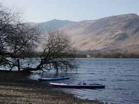 A lake with trees and kayaks by the shore at Fellfoot Cottage in 