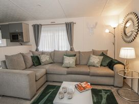 A living room with a sectional sofa and a coffee table at The Ridgeway in New Quay