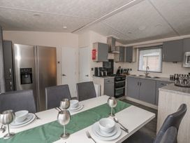 A kitchen with dining table and appliances at The Ridgeway in New Quay