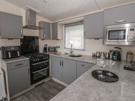 A kitchen with cabinets, stove, oven, sink and microwave at The Ridgeway in New Quay