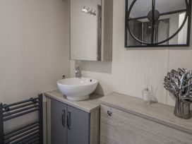 A bathroom with a wash basin and mirror at The Ridgeway in New Quay