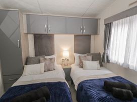 A bedroom with twin beds and a bedside table at The Ridgeway in New Quay