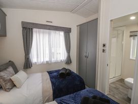 A bedroom with two beds and a wardrobe at The Ridgeway in New Quay