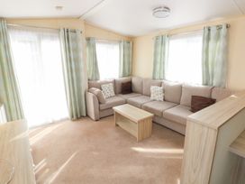 A living room with a sofa and coffee table at Under cliff caravan in Ferryside