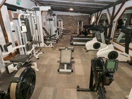 A gym with various exercise machines and a weight bench at Under cliff caravan Ferryside