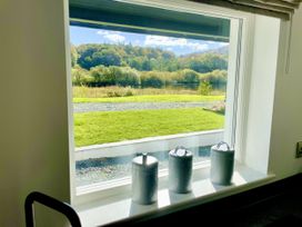 A window with canisters overlooking a grassy area at The Dove Cot in Ambleside