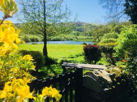 A garden with a view of a lake and flowers at The Dove Cot in Ambleside
