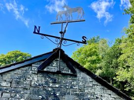 A weather vane featuring horses on top of a roof at The Dove Cot in Ambleside