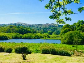 A view of a lake surrounded by hills and trees at The Dove Cot in Ambleside